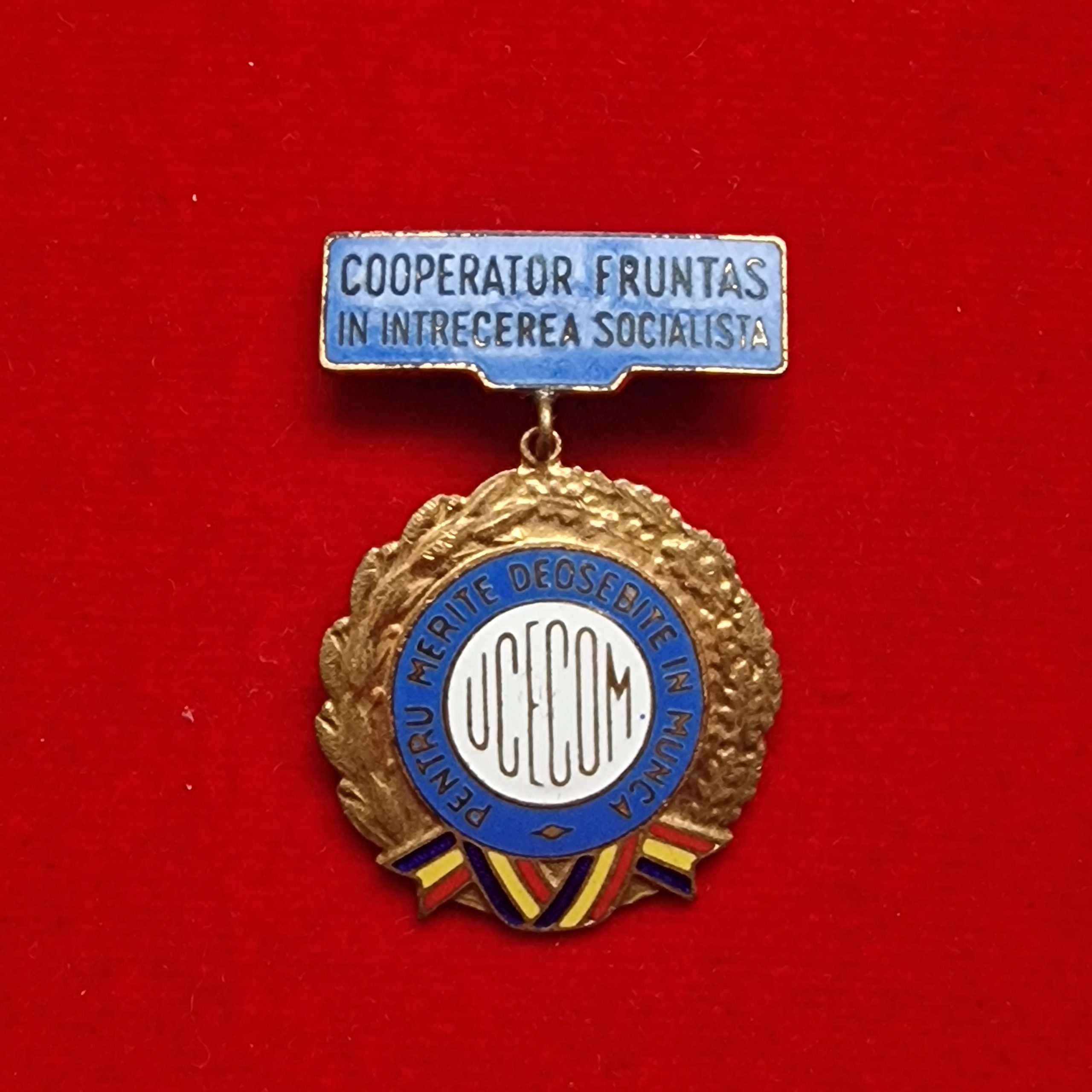 Insigna UCECOM - Cooperator fruntaș în întrecerea socialistă - Pentru merite deosebite în muncă